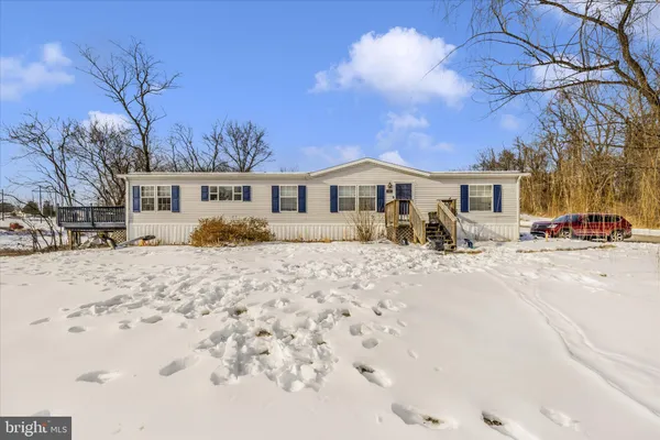 a view of a white house with a yard covered in snow