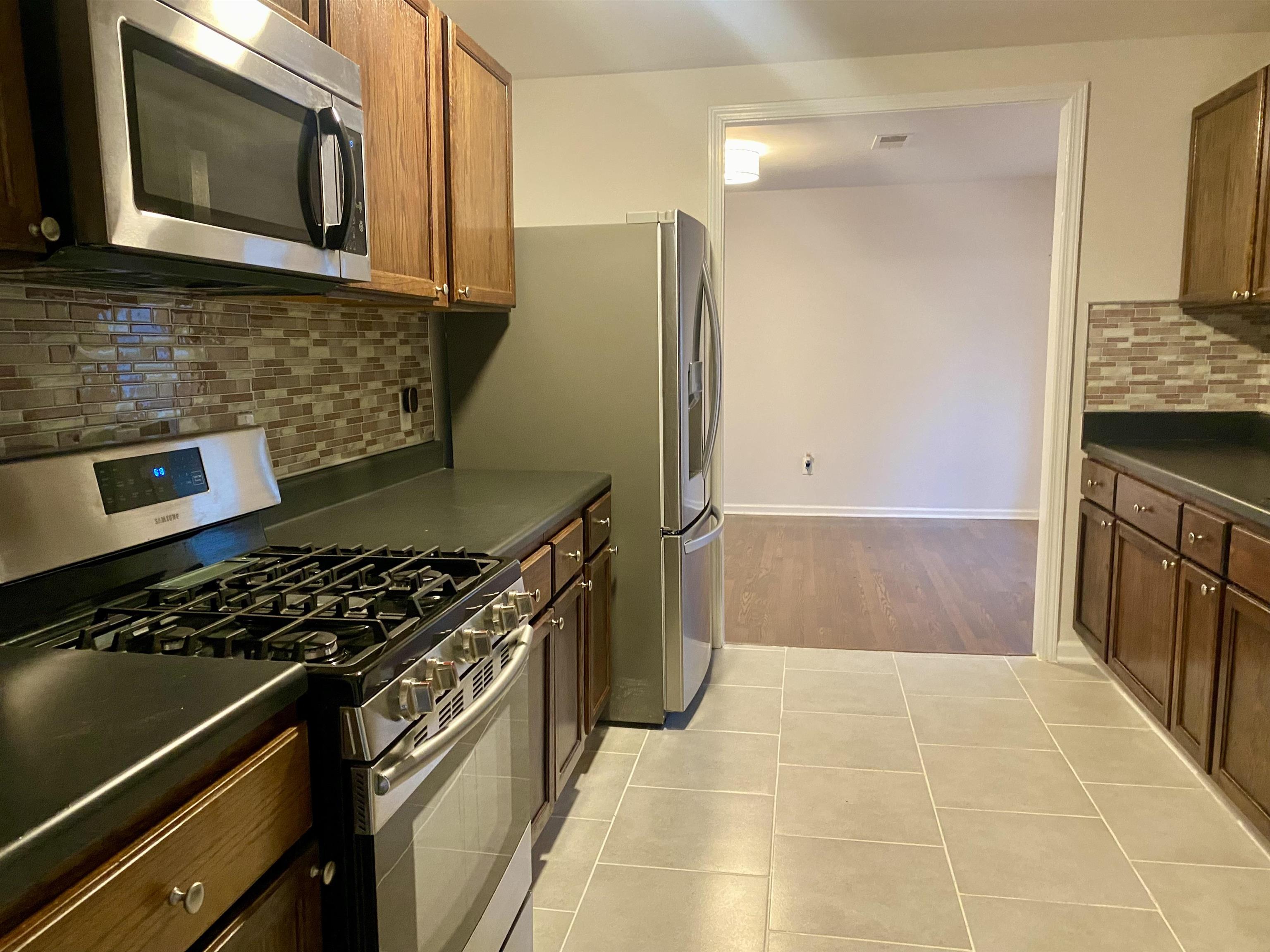 502 James Avenue Covington, TN 38019 - Photo 14 of 40 a kitchen with stainless steel appliances granite countertop a stove and a microwave