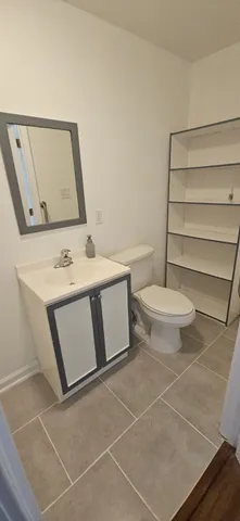a bathroom with a toilet sink and mirror
