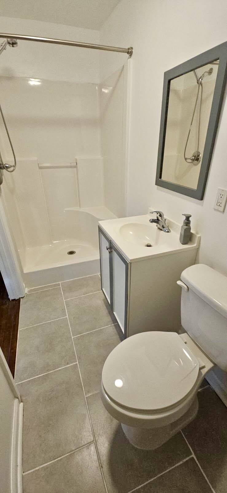 502 James Avenue Covington, TN 38019 - Photo 21 of 40 a bathroom with a toilet a sink a mirror and vanity