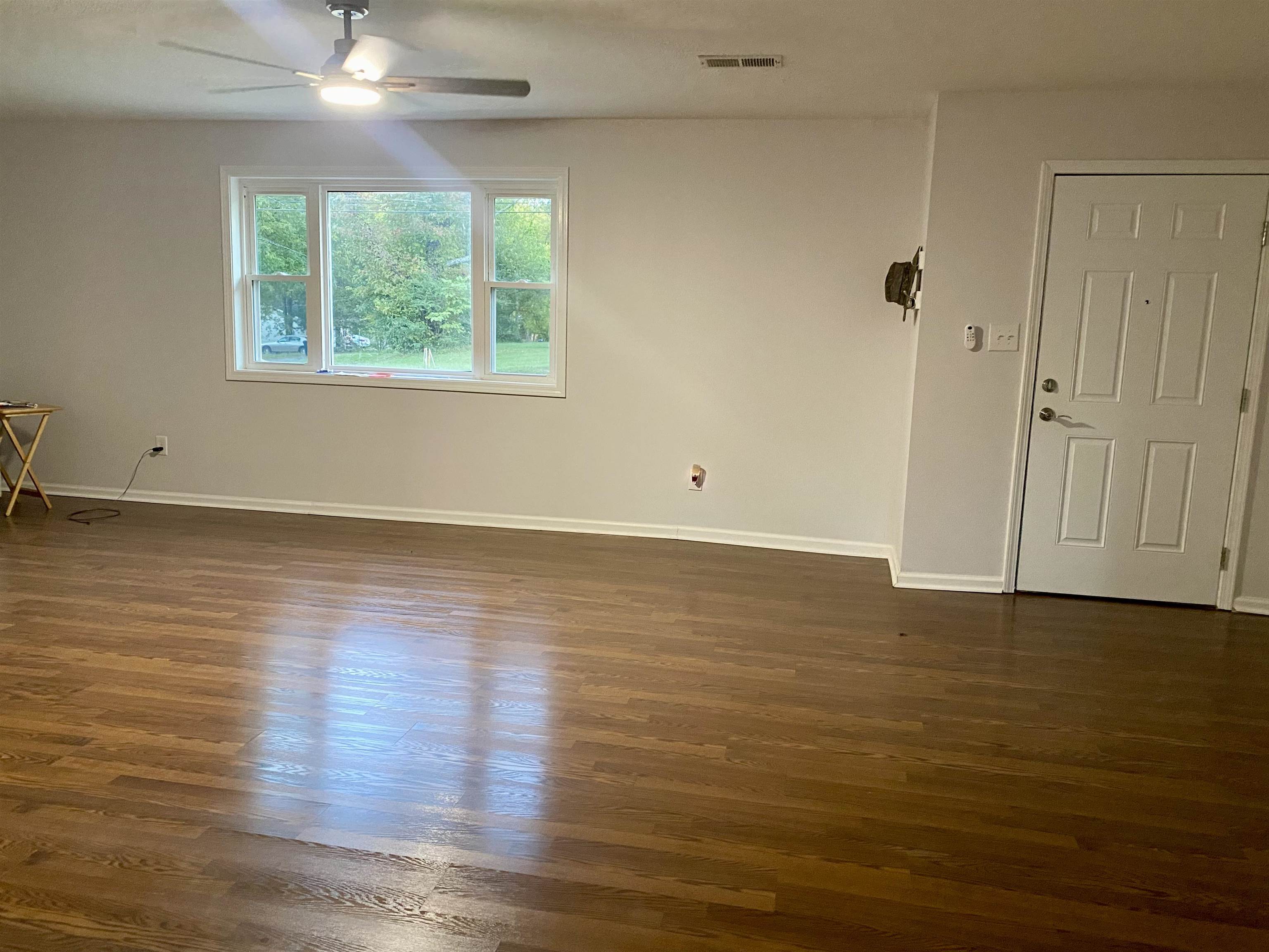 502 James Avenue Covington, TN 38019 - Photo 9 of 40 an empty room with wooden floor and windows