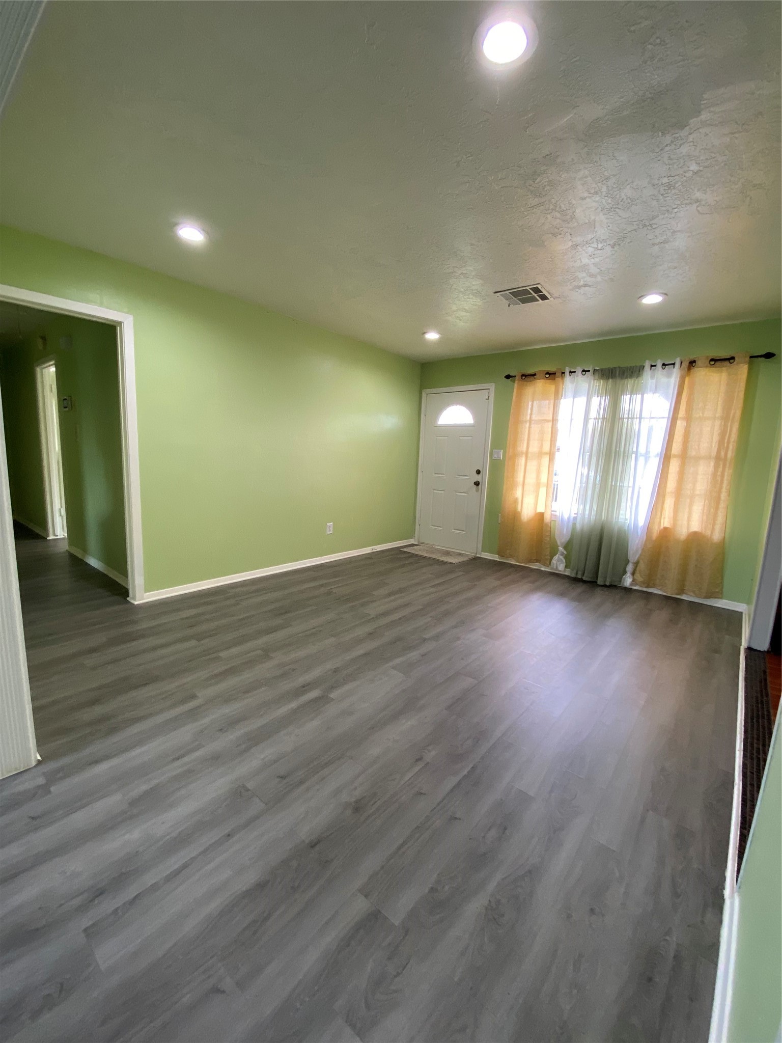 15513 Vonnet Street Channelview, TX 77530 - Photo 3 of 10 an empty room with wooden floor and windows