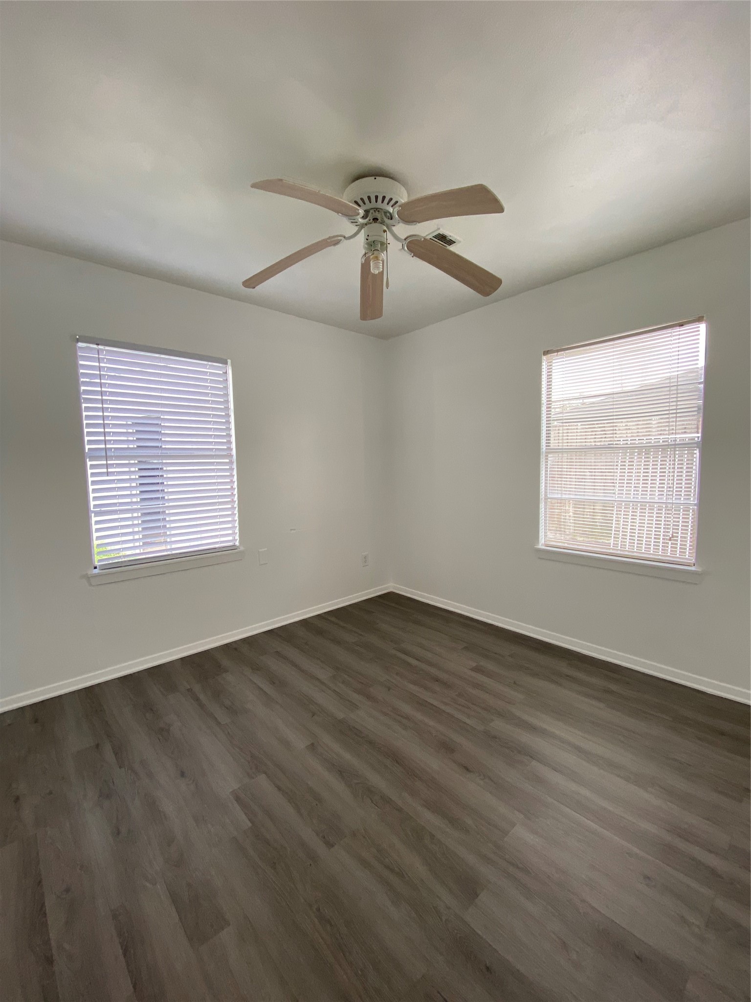 15513 Vonnet Street Channelview, TX 77530 - Photo 7 of 10 an empty room with wooden floor ceiling fan and windows