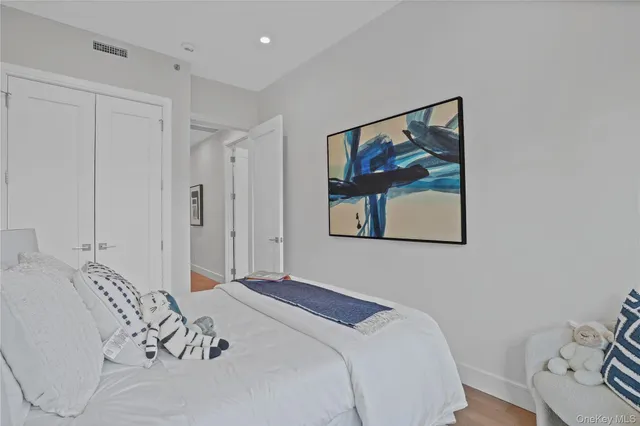a bedroom with a large bed and a painting on the wall