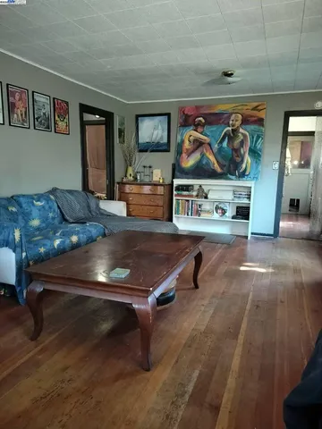 a living room with furniture and wall paintings