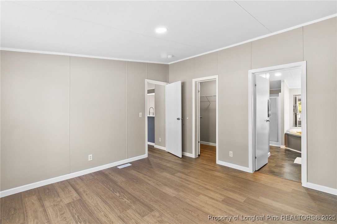 1334 East Green Springs Road Parkton, NC 28371 - Photo 13 of 32 a view of an empty room with wooden floor and a bathroom