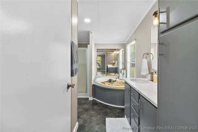 a room with stainless steel appliances kitchen island granite countertop a sink and cabinets with wooden floor