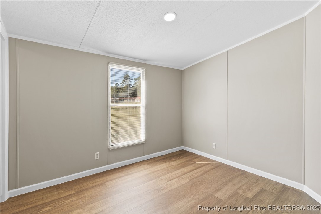 1334 East Green Springs Road Parkton, NC 28371 - Photo 19 of 32 an empty room with wooden floor and windows