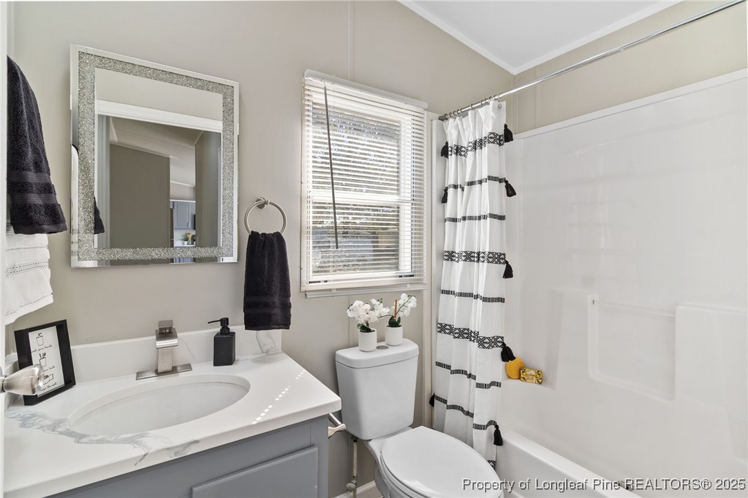 1334 East Green Springs Road Parkton, NC 28371 - Photo 22 of 32 a bathroom with a sink toilet vanity mirror and shower