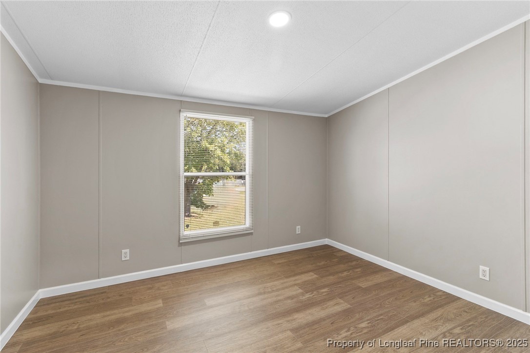 1334 East Green Springs Road Parkton, NC 28371 - Photo 25 of 32 an empty room with wooden floor and windows