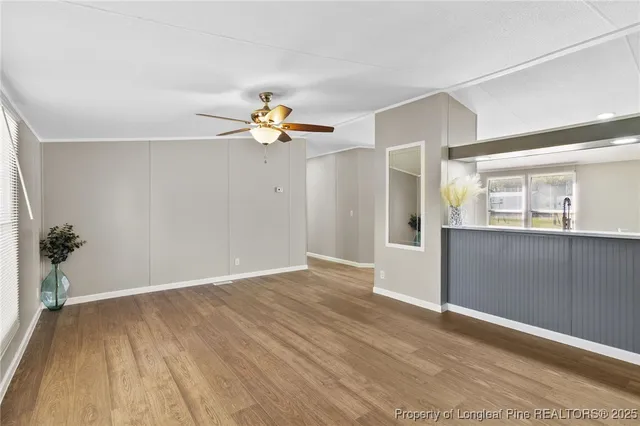 an empty room with wooden floor and natural light