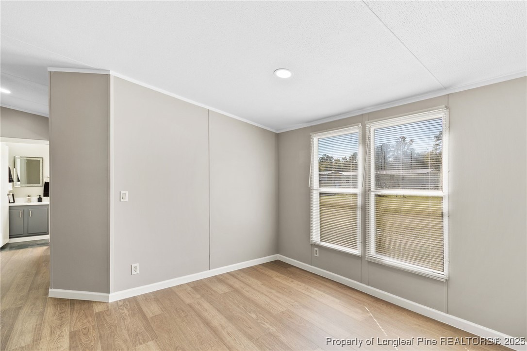 1334 East Green Springs Road Parkton, NC 28371 - Photo 7 of 32 a view of an empty room with wooden floor and a window