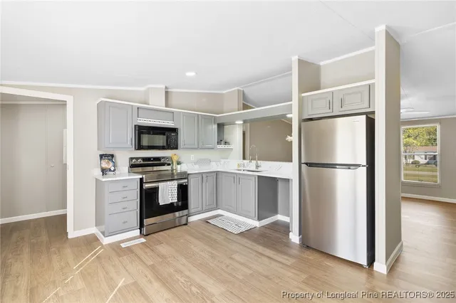 a kitchen with cabinets stainless steel appliances and wooden floor