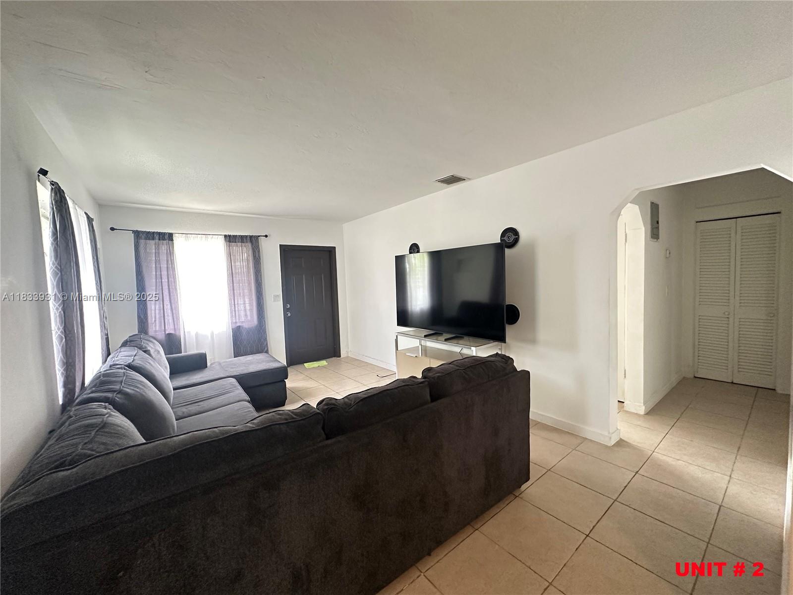 809 Northeast 2nd Street, Unit 12 Hallandale Beach, FL 33009 - Photo 12 of 19 a living room with furniture and a flat screen tv