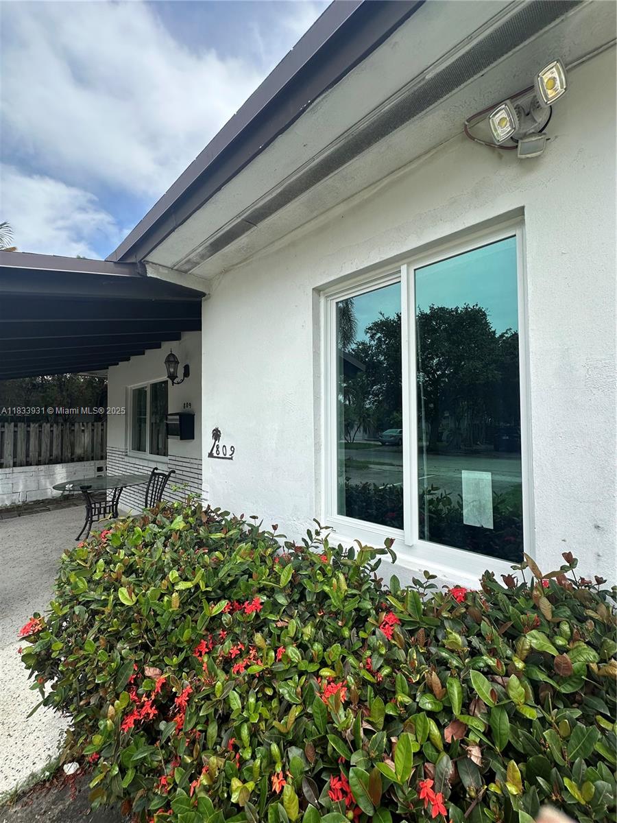 809 Northeast 2nd Street, Unit 12 Hallandale Beach, FL 33009 - Photo 16 of 19 front view of a house with a big yard and potted plants