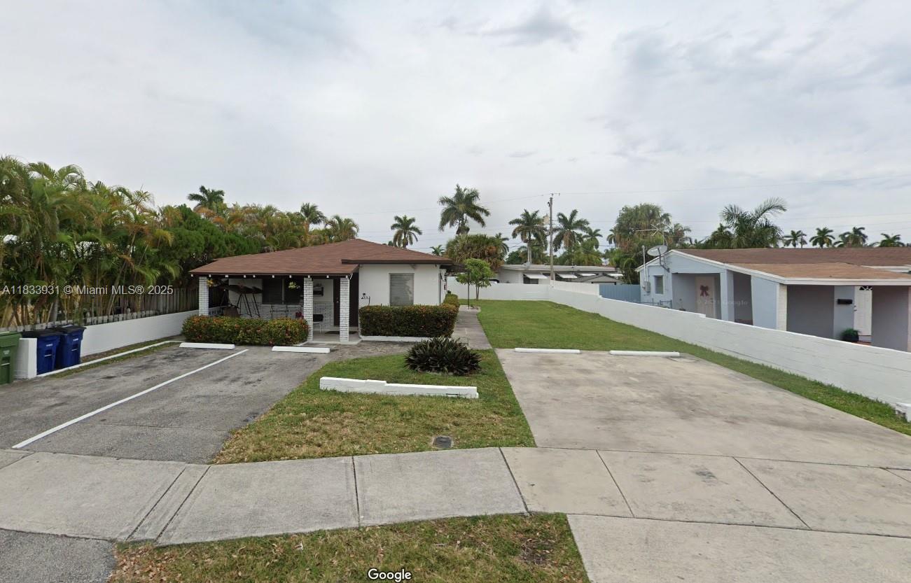 809 Northeast 2nd Street, Unit 12 Hallandale Beach, FL 33009 - Photo 18 of 19 a front view of a house with a yard