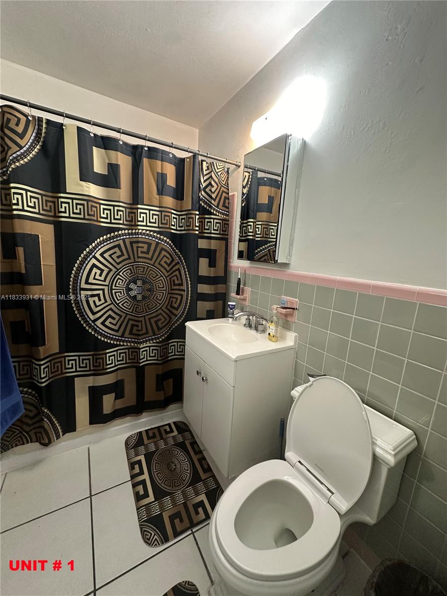 809 Northeast 2nd Street, Unit 12 Hallandale Beach, FL 33009 - Photo 8 of 19 a bathroom with a toilet a sink and mirror