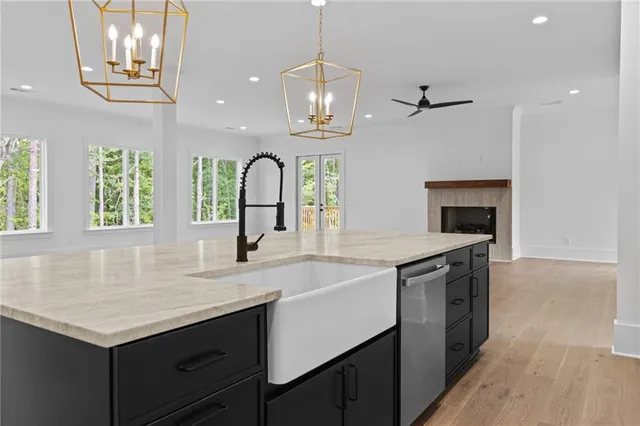 a large kitchen with kitchen island a sink stainless steel appliances and a fireplace