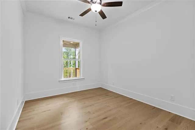 an empty room with window and ceiling fan