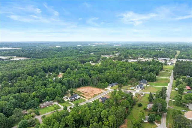 an aerial view of residential houses with outdoor space and trees