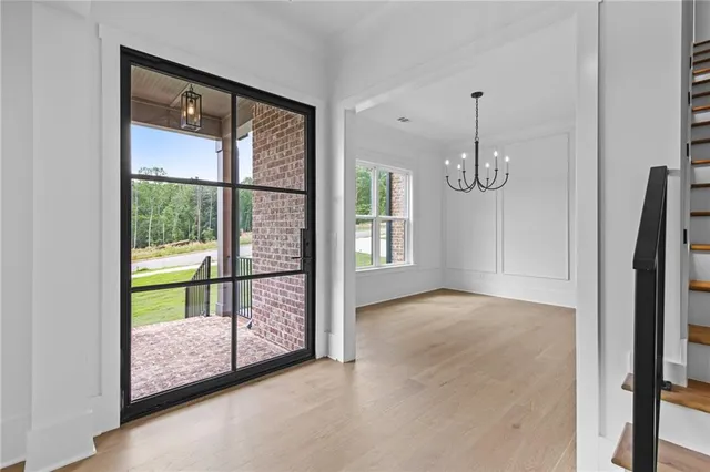 a view of an empty room with window and wooden floor