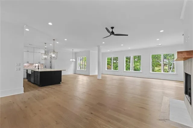 an empty room with windows and fireplace