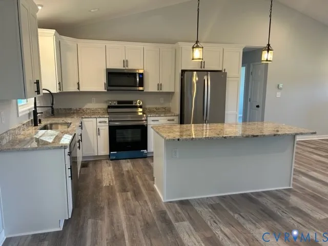 a kitchen with stainless steel appliances granite countertop a stove a sink and a refrigerator