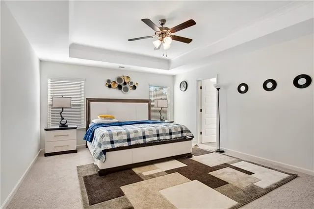 a bed sitting in a bedroom next to a window and a chandelier