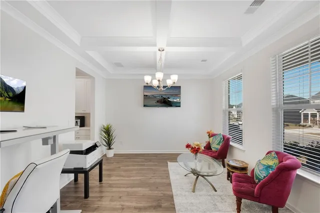 a living room with furniture a chandelier and a wooden floor