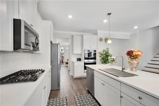 a kitchen with white cabinets and stainless steel appliances