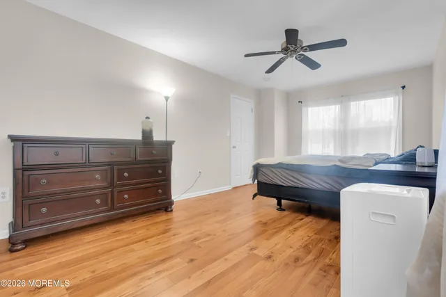 a room with a dresser and a ceiling fan