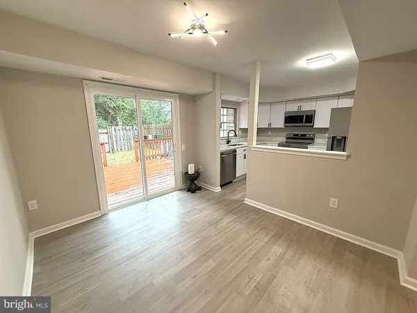 a kitchen with stainless steel appliances granite countertop a refrigerator a sink dishwasher a stove and a refrigerator with wooden floor