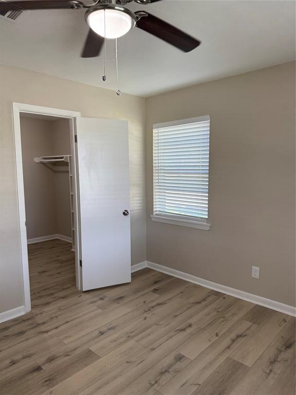 711 Farmington Road Howe, TX 75459 - Photo 15 of 21 an empty room with wooden floor cabinet and windows