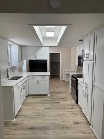 a large kitchen with cabinets and stainless steel appliances