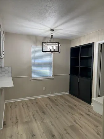 a view of empty room with wooden floor and windows