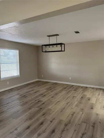 a view of a room with wooden floor and window