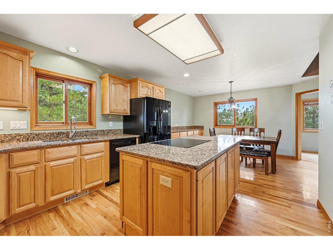 256 Choctaw Road Lyons, CO 80540 - Photo 16 of 50 a kitchen with granite countertop a stove a sink a dining table and chairs