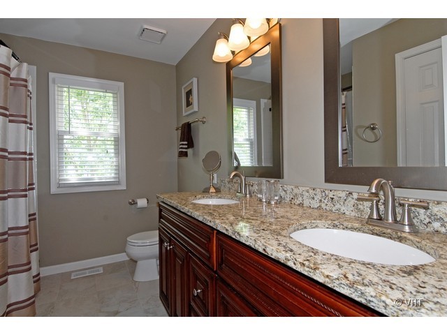 3530 Monarch Circle Naperville, IL 60564 - Photo 13 of 19 a bathroom with a granite countertop sink a toilet and a mirror