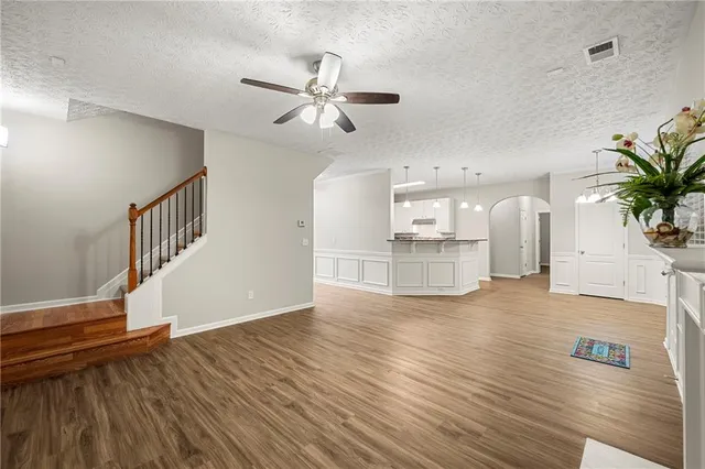 a view of an empty room with wooden floor and a potted plant