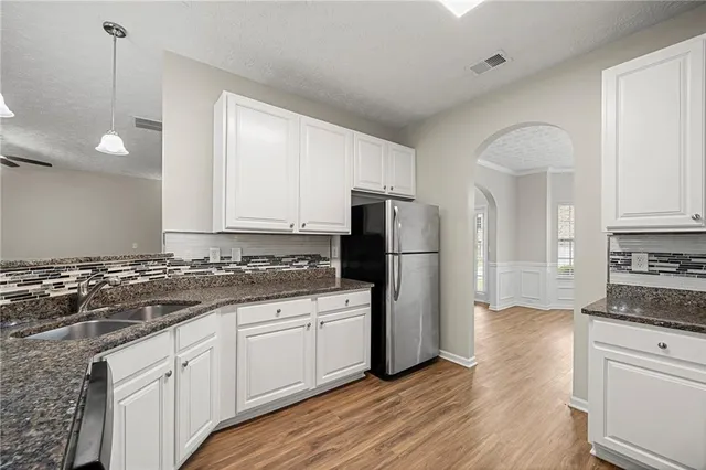 a kitchen with a refrigerator a stove a microwave and cabinets