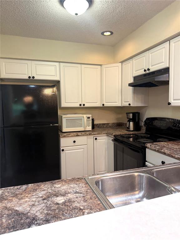 1340 Cypress Cove Court Inverness, FL 34450 - Photo 12 of 30 a kitchen with stainless steel appliances granite countertop a stove a refrigerator and a sink with wooden cabinets