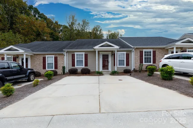 a view of a white house with a large space and a yard