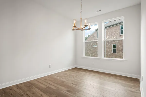 a view of empty room with wooden floor ceiling fan and window