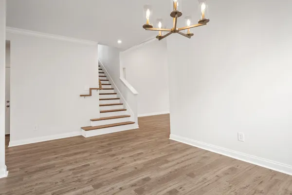 a view of a hallway with wooden floor and entryway