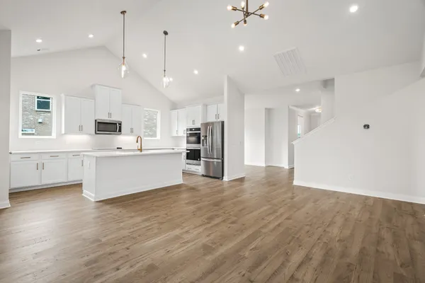 a view of kitchen with kitchen island white cabinets and stainless steel appliances