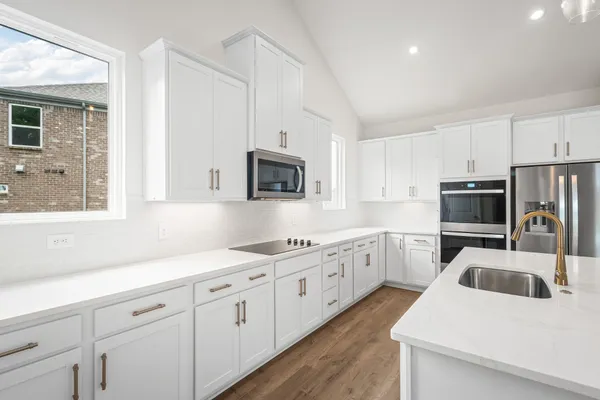 a kitchen with granite countertop white cabinets white stainless steel appliances and sink