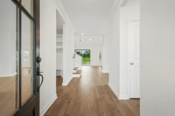 a view of a hallway with wooden floor and staircase
