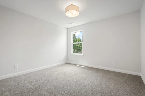 an empty room with a window and a ceiling fan