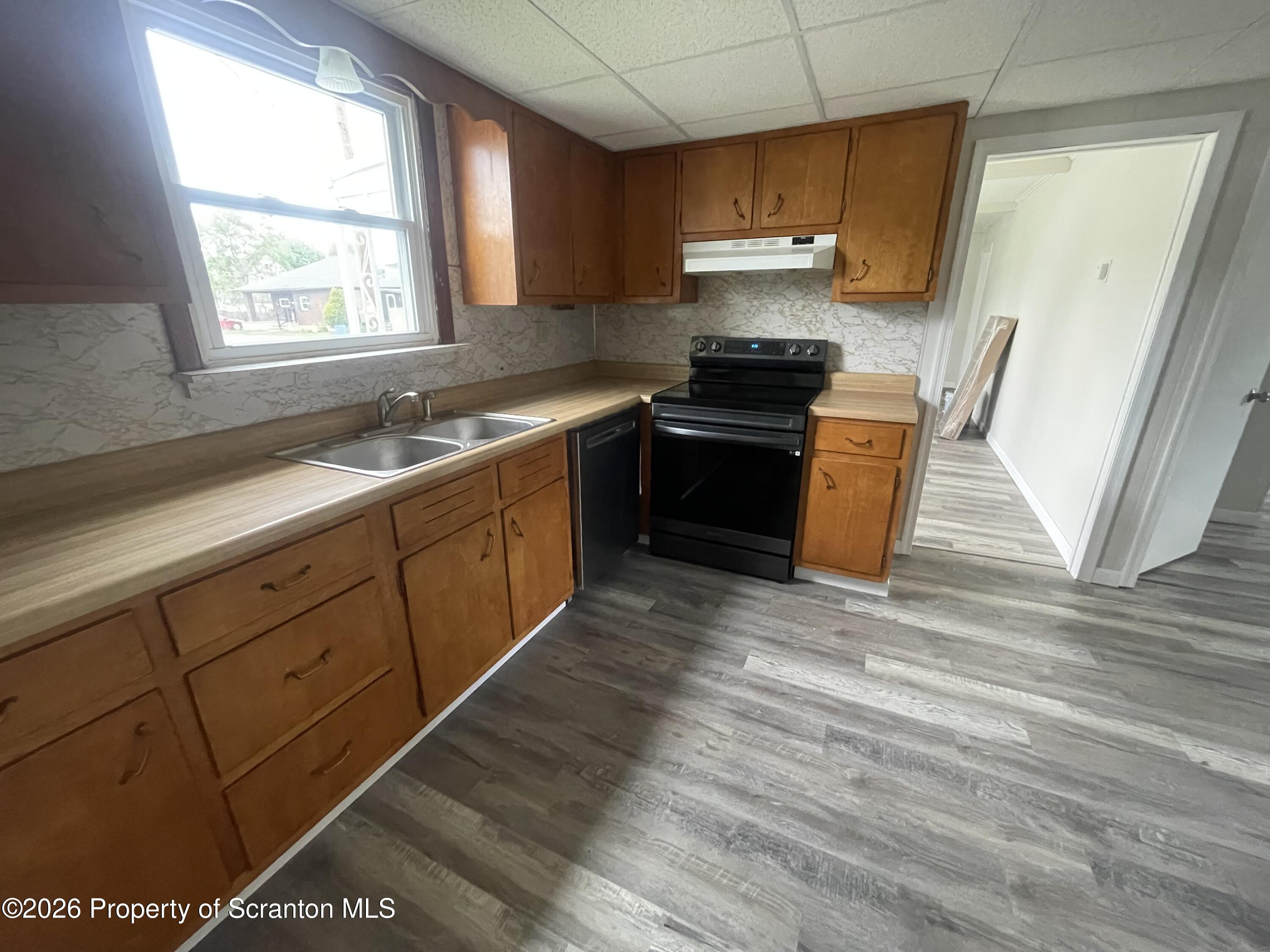 238 George Street Moosic, PA 18507 - Photo 4 of 23 a kitchen with stainless steel appliances granite countertop a sink a stove a refrigerator wooden floor and cabinets
