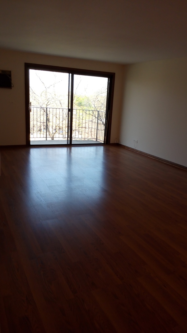 Undisclosed Address Chicago, IL 60630 - Photo 5 of 15 a view of an empty room with wooden floor and a window